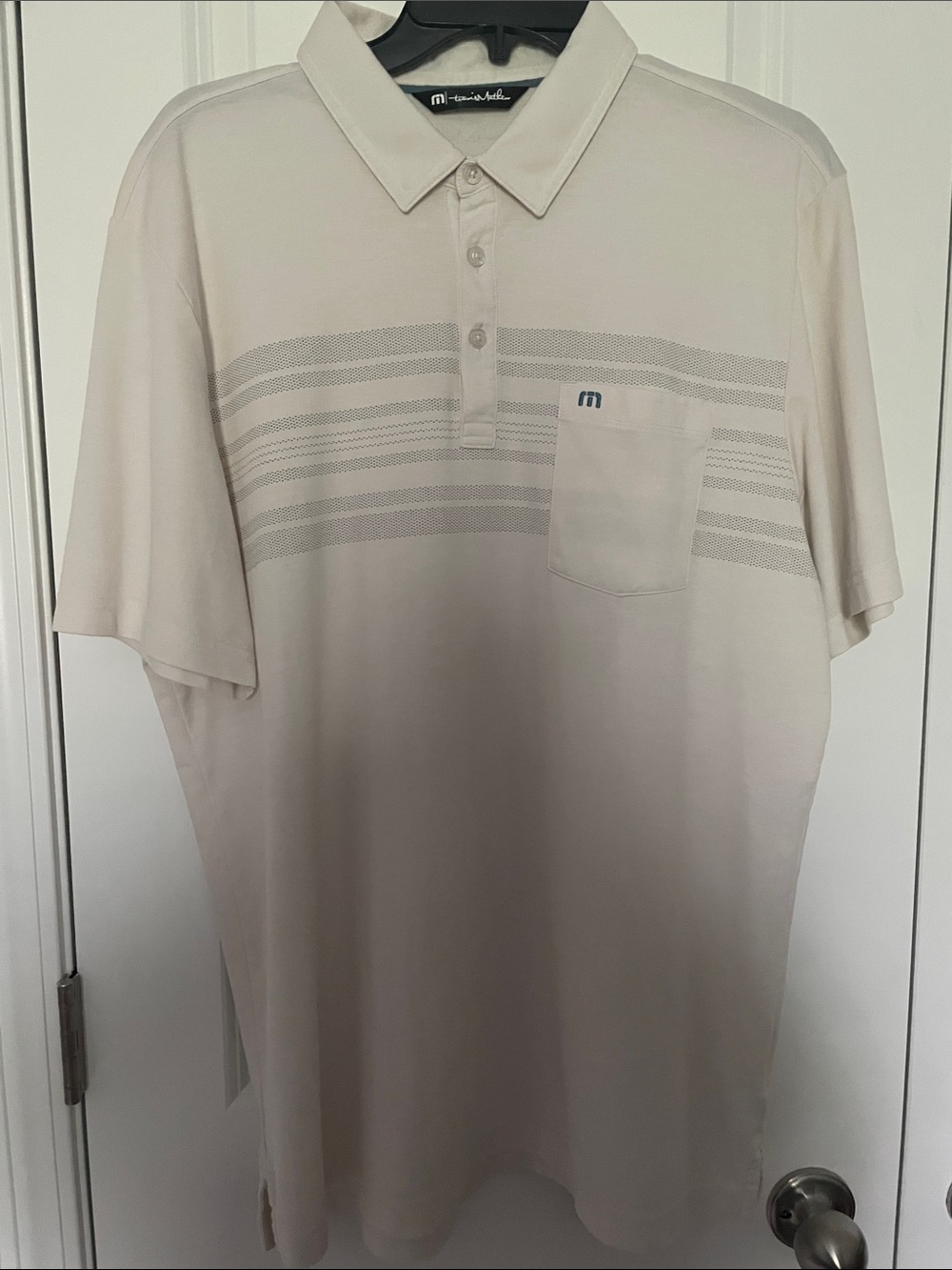 Travis Mathew’s Beige Short Sleeve Polo with Subtle Stripes